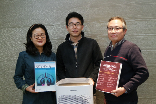 정우경 삼성전자 생활가전사업부 수석, 정세관 책임, 우동우 수석(왼쪽부터)이 영국 의학 전문저널 '천식 학회지'와 '에어로졸 과학기술학회지'를 들고 삼성 블루스카이 공기청정기와 함께 사진을 찍고 있다. <삼성전자 제공>